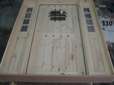 Exterior pine door with iron grill and clavos and matching sidelights